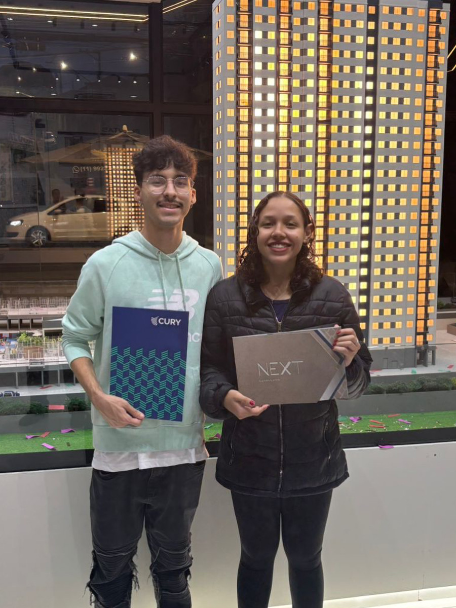 Casal comemorando a conquista do apartamento no stand.